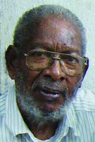 An older man wearing glasses and a striped shirt.