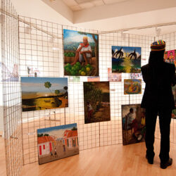 A person standing in front of a display of pictures.